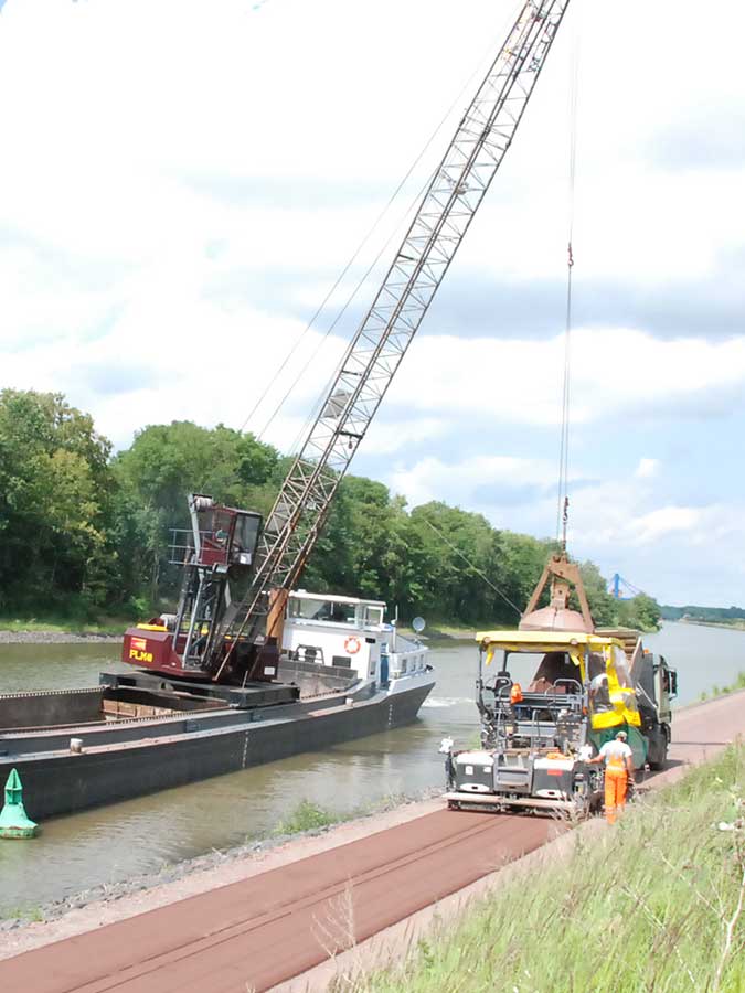 Asphaltfertiger bringt roten Asphalt auf