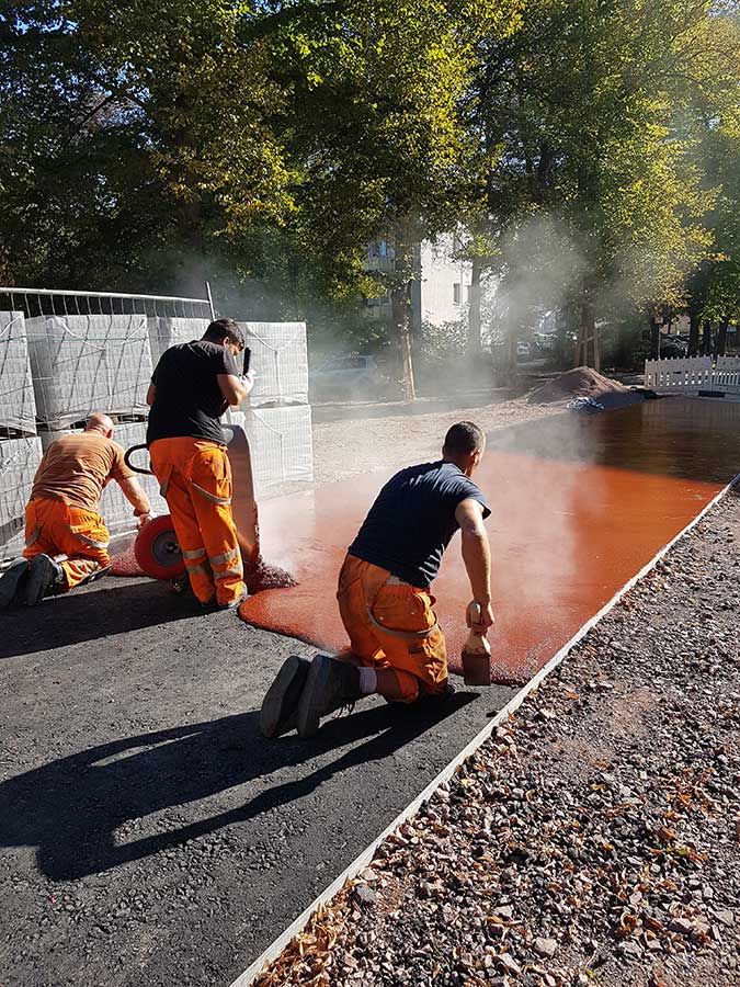 Arbeiter vergießen roten Asphalt